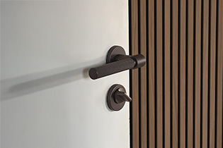 Door handle Helix 200 in dark bronze mounted on a door