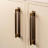 Fluted handle in antique brass with back plate in a bright kitchen.